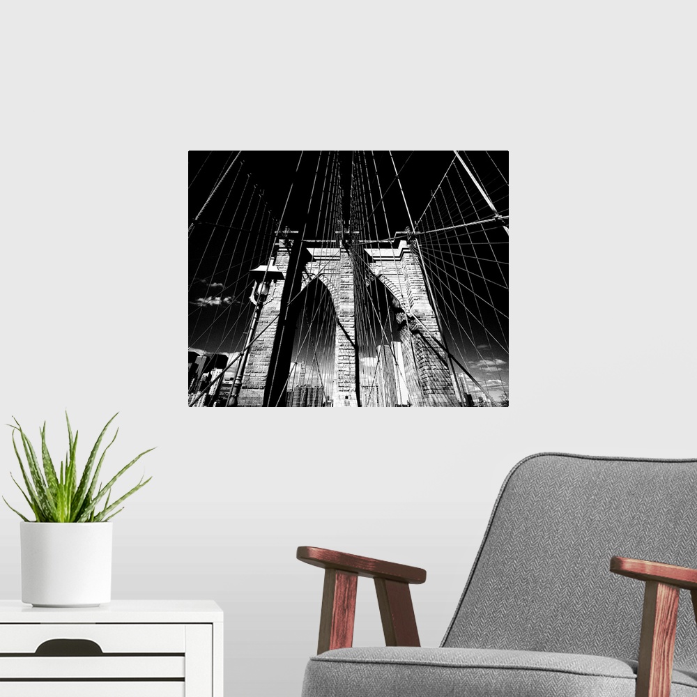 A modern room featuring Dramatic black and white photograph of the Brooklyn bridge arches and suspension cables.