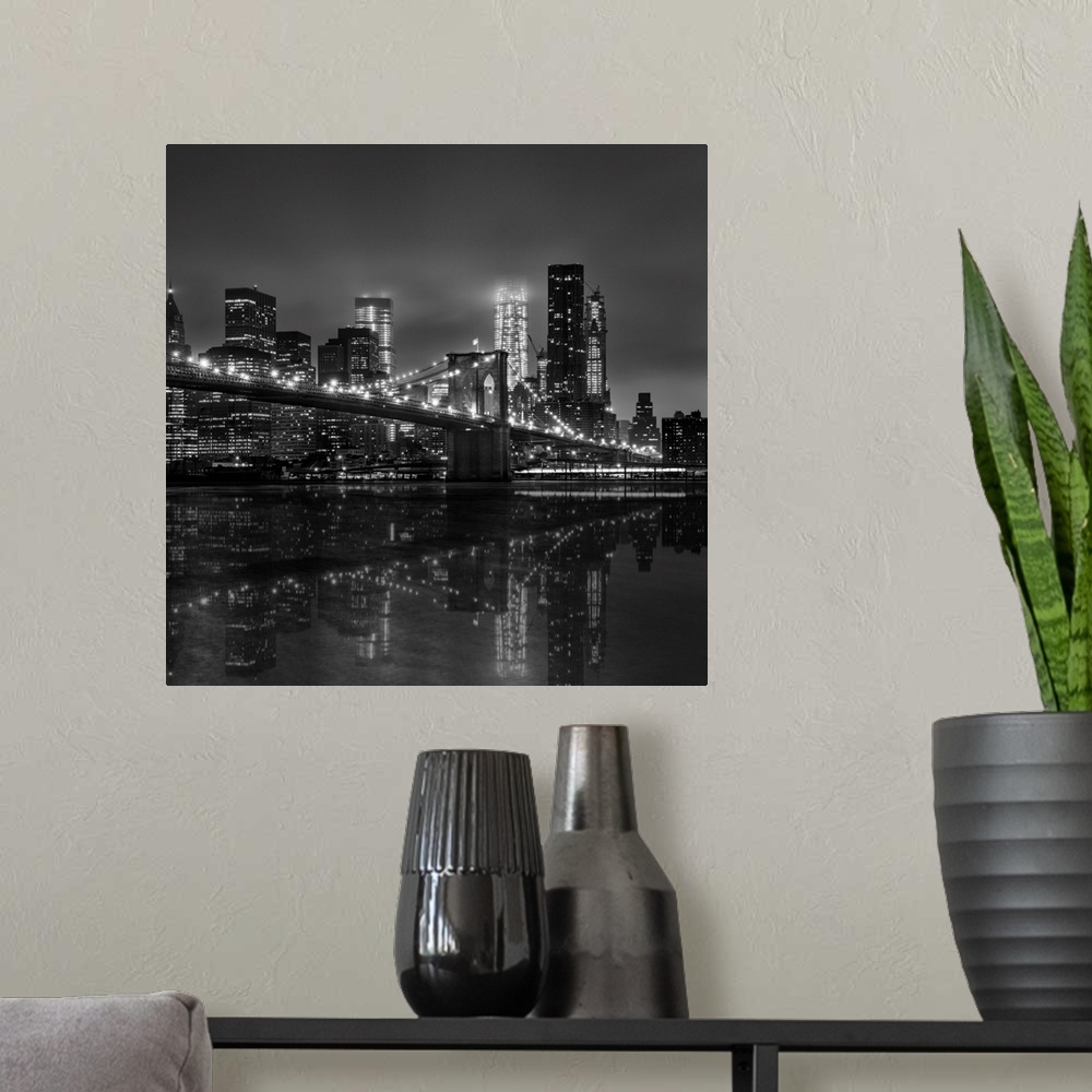 A modern room featuring Black and white photograph of New York city's skyline at night with the Brooklyn bridge in the fo...