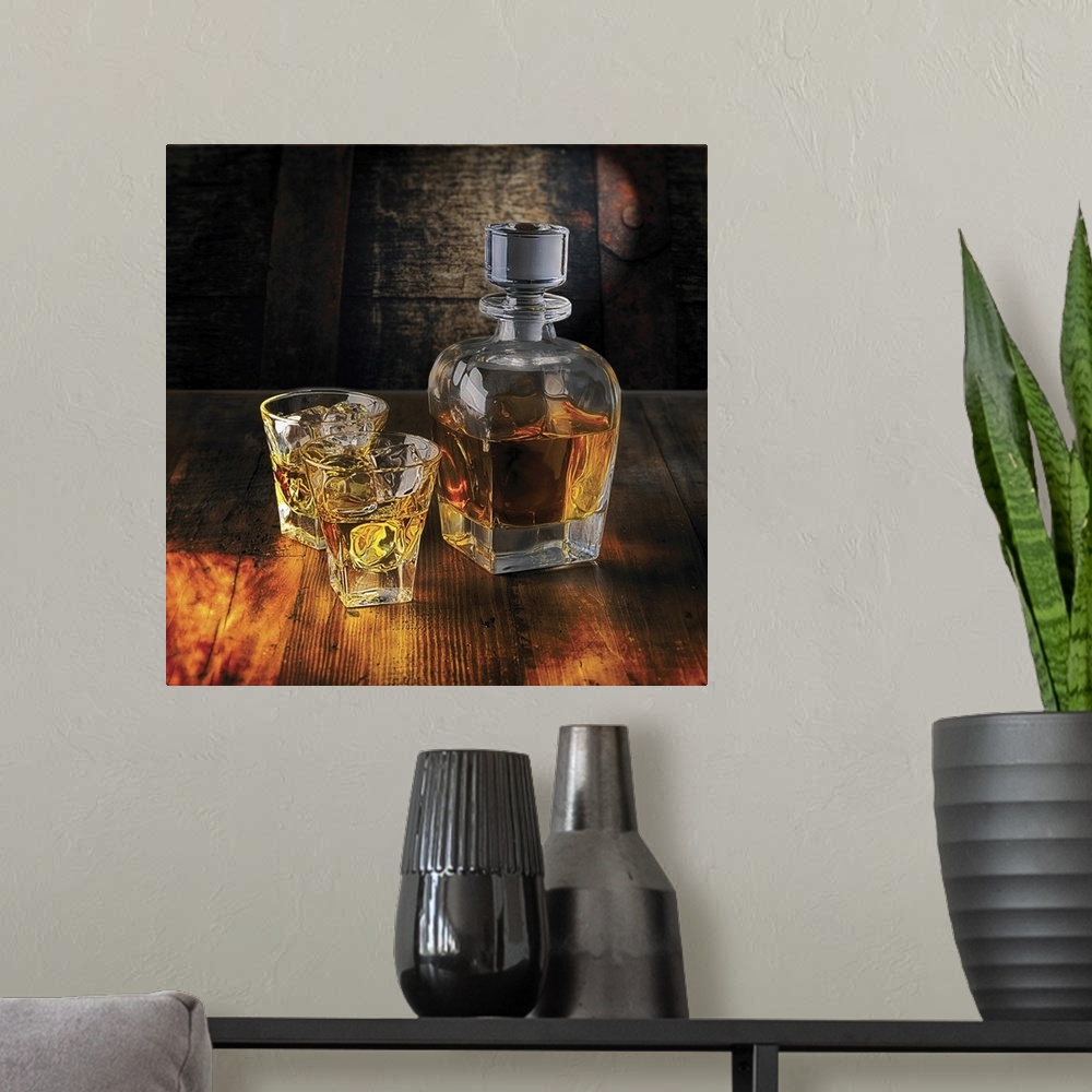 A modern room featuring A Whiskey Bottle and Two Glasses on the Rocks on a Wooden Table.