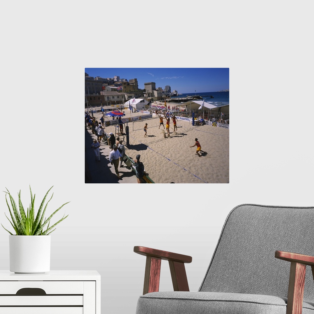 A modern room featuring High angle view of a group of men playing volleyball on the beach, Plage des Catalans, Marseille,...
