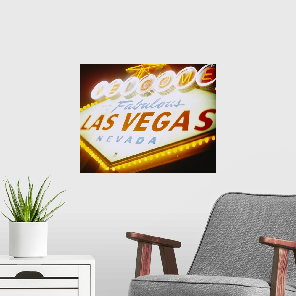 A modern room featuring Large photograph focuses on a close-up of the famous neon sign somebody can see as they enter the...