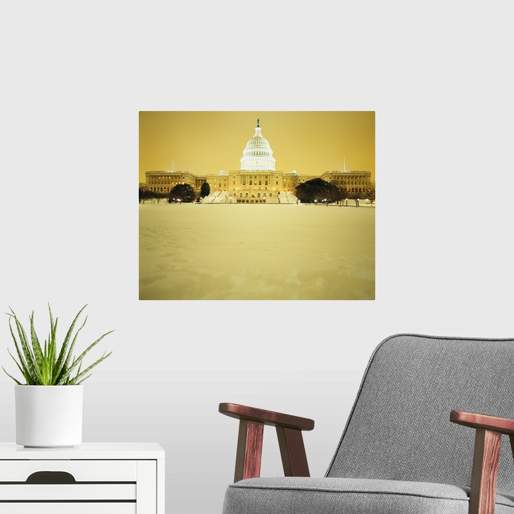 A modern room featuring US Capitol Building illuminated at night with snow, Washington DC