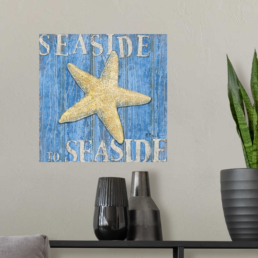 A modern room featuring Square painting of a starfish on blue wood panels with the text Seaside to Seaside.