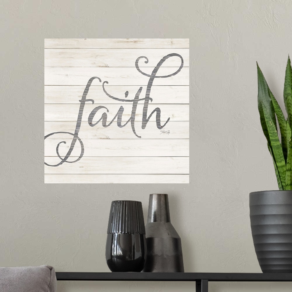A modern room featuring "Faith" situated on a white shiplap background.