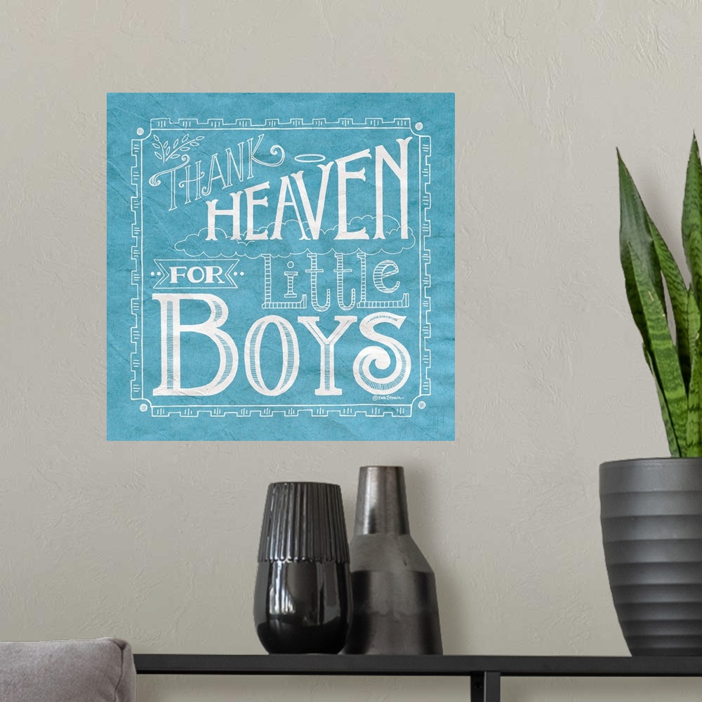 A modern room featuring Handlettered home decor art for a boy's room, with white lettering against a distressed blue back...