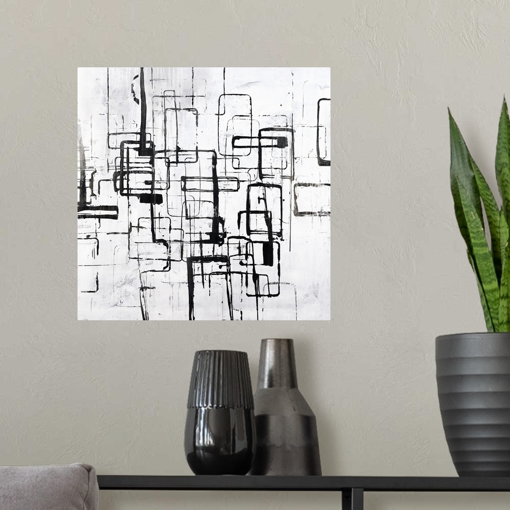A modern room featuring Black and white painting of curved square shapes in varies sizes overlapping.