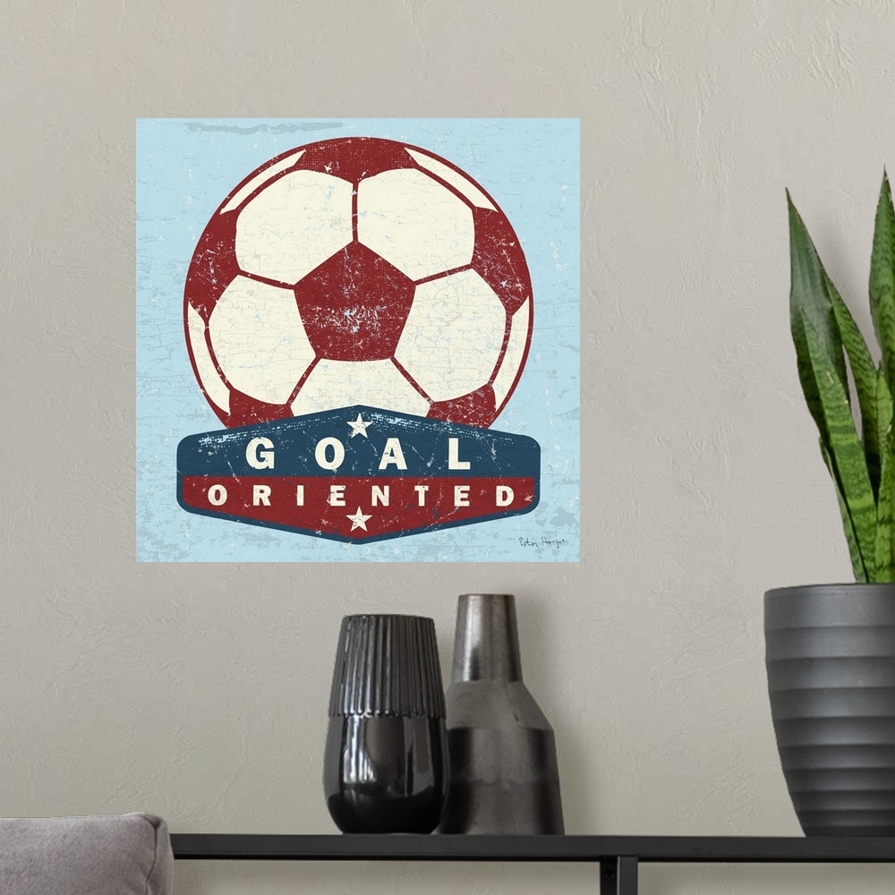 A modern room featuring Distressed  large red soccer ball with a typography saying Goal Oriented.