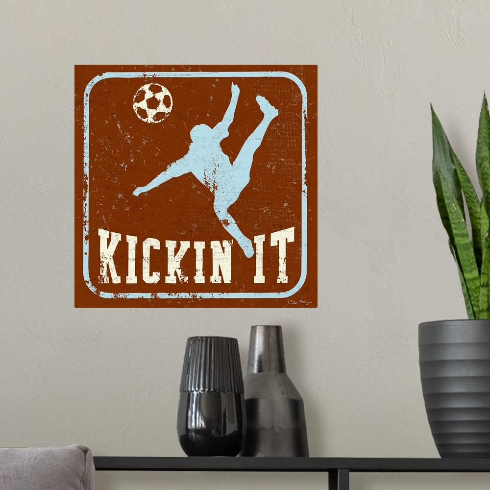A modern room featuring Distressed image of soccer player kicking a soccer ball with the words Kickin' It underneath.