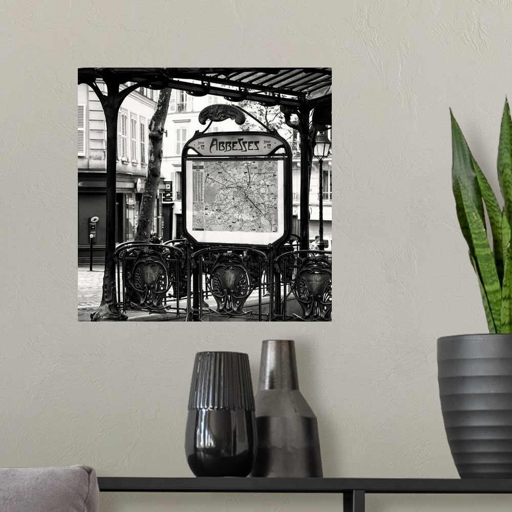 A modern room featuring A black and white photograph of the Abbesses subway station sign in Paris.