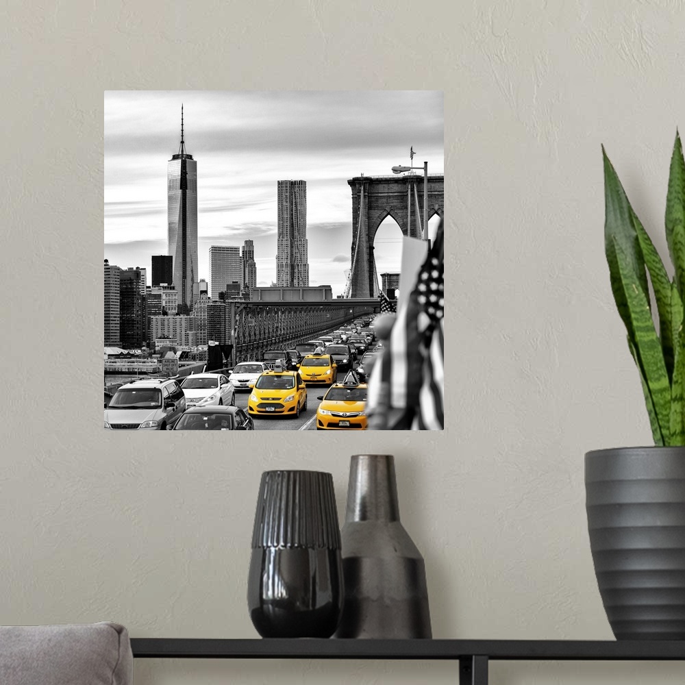 A modern room featuring A black and white photograph of the One World Trade building from the Brooklyn bridge with yellow...