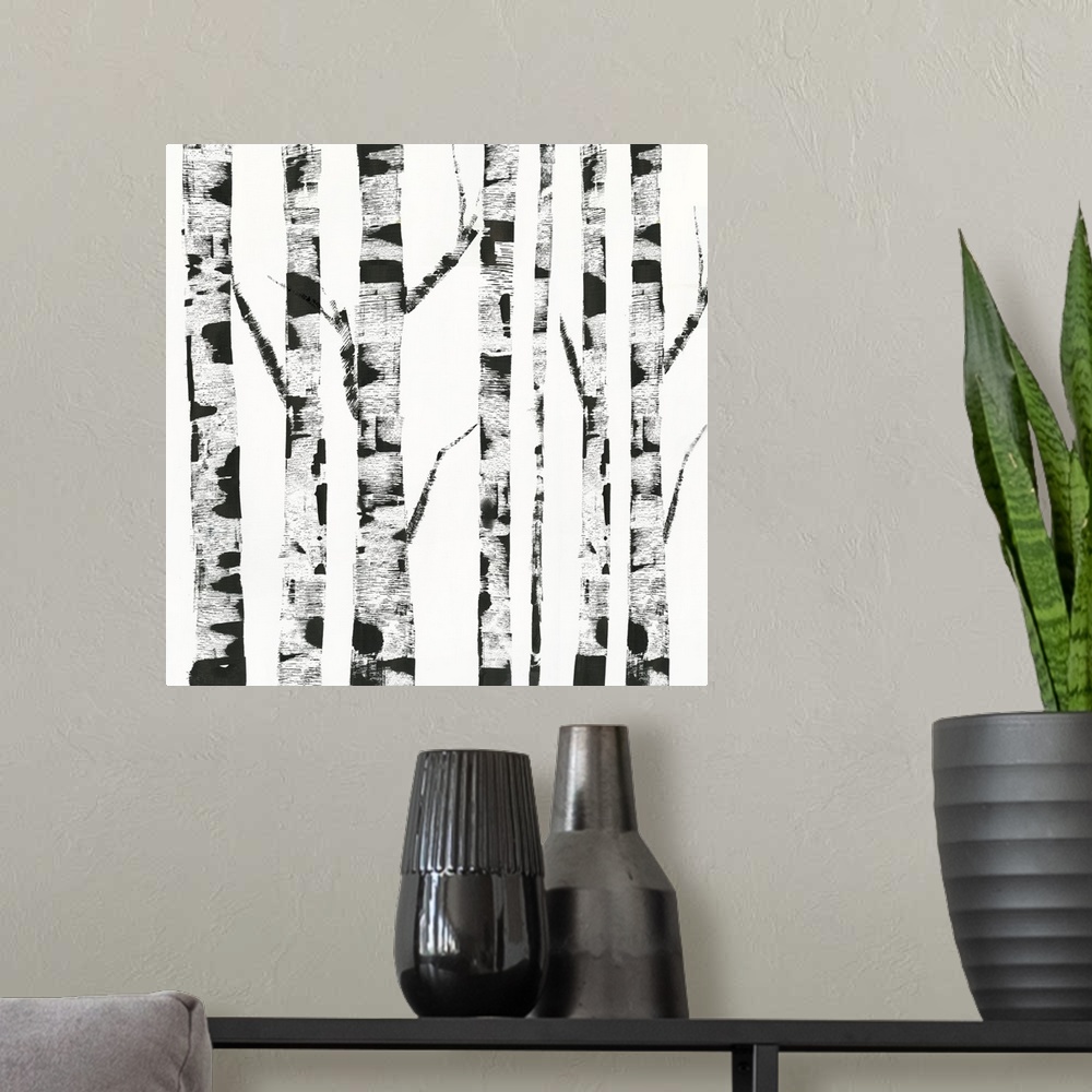 A modern room featuring White and black artwork of birch trunks.