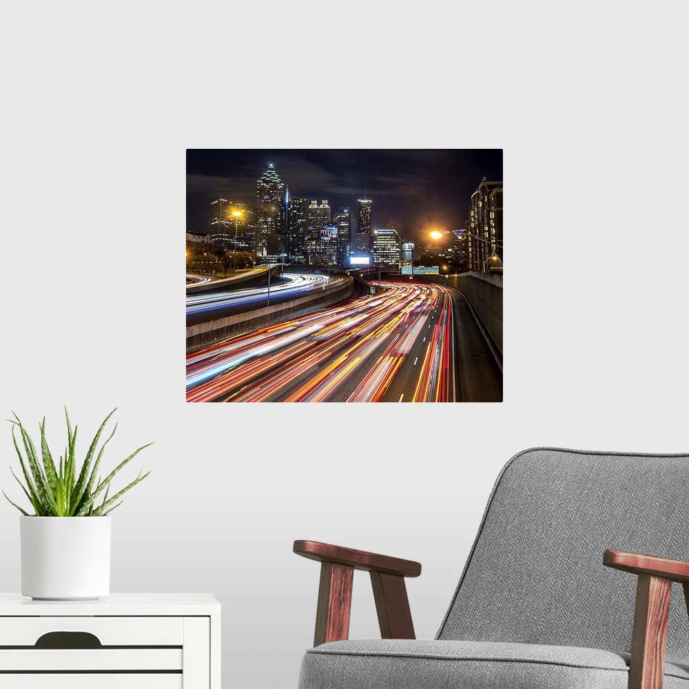 A modern room featuring Light trails from traffic leading into the city of Atlanta, Georgia, at night.