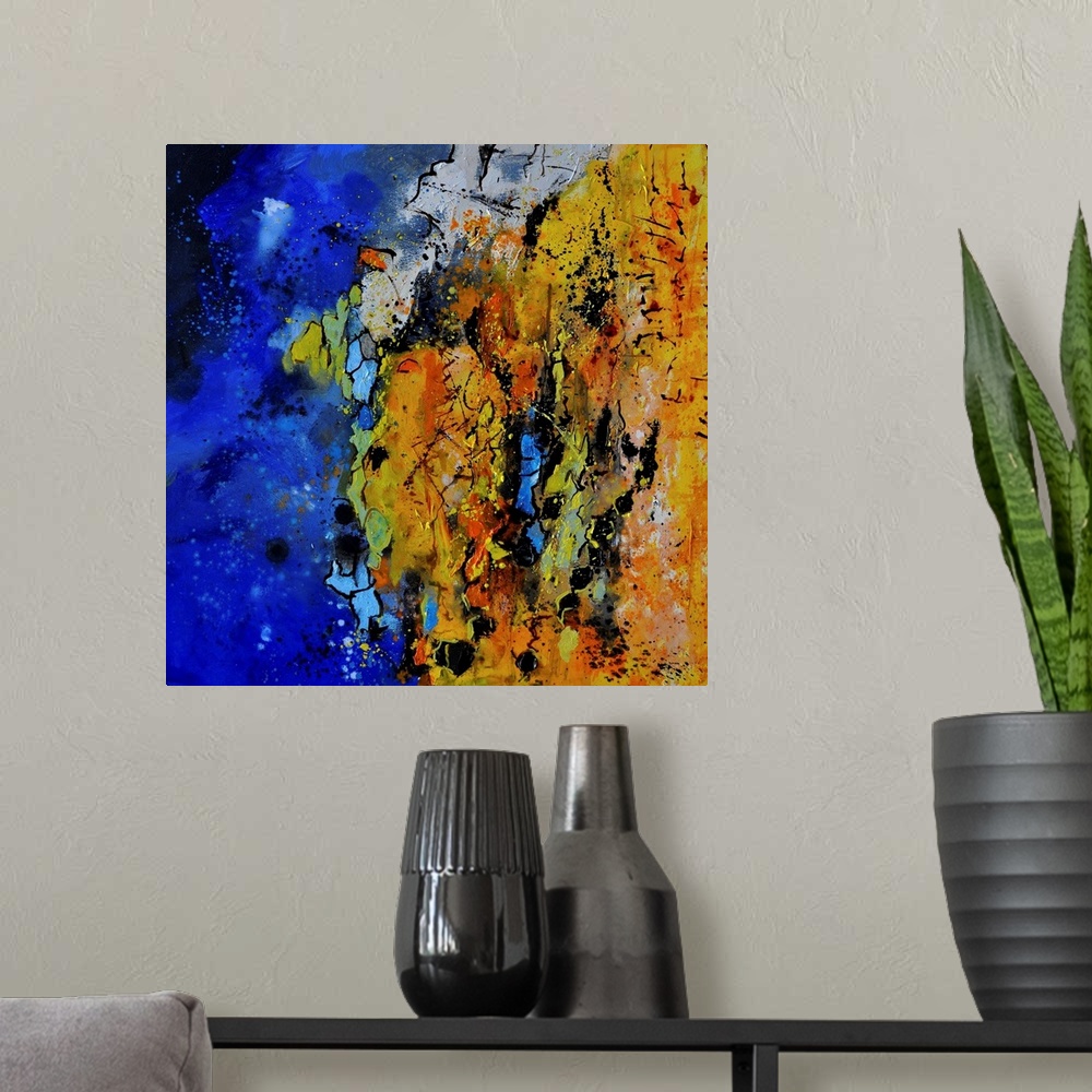 A modern room featuring A square abstract painting with vibrant colors of blue, orange and yellow.