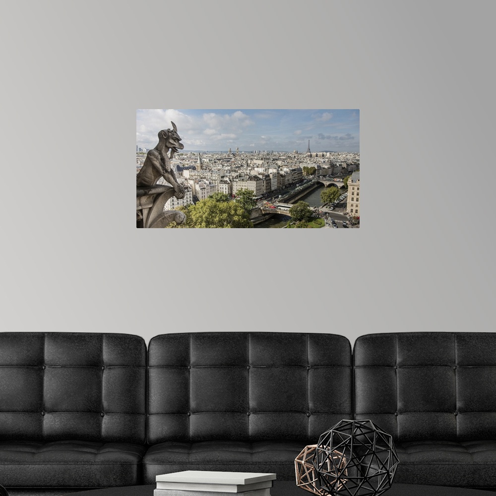 A modern room featuring Photograph of a gargoyle statue watching over the city of Paris.