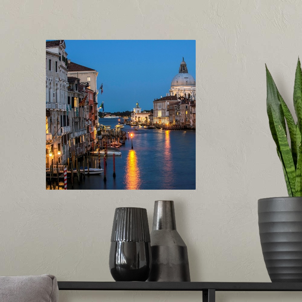 A modern room featuring Square photograph of Grand Canal lit up at night with the Santa Maria della Salute in the backgro...