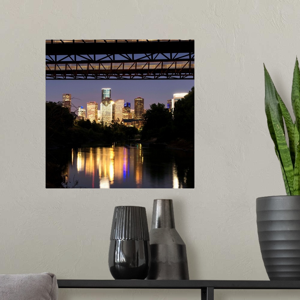 A modern room featuring Square photograph of the Houston TX skyline at night reflecting into the Buffalo Bayou with the R...