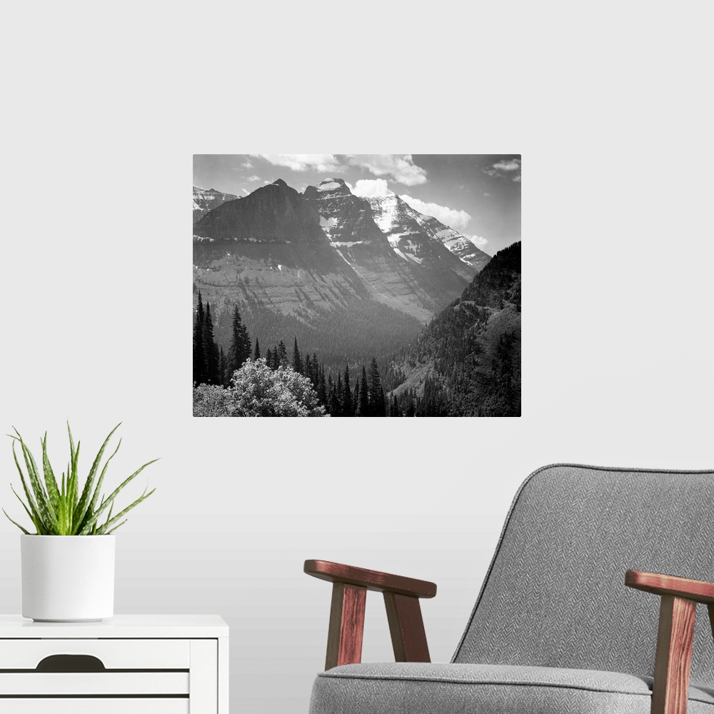 A modern room featuring In Glacier National Park, valley, snow covered mountains in background.