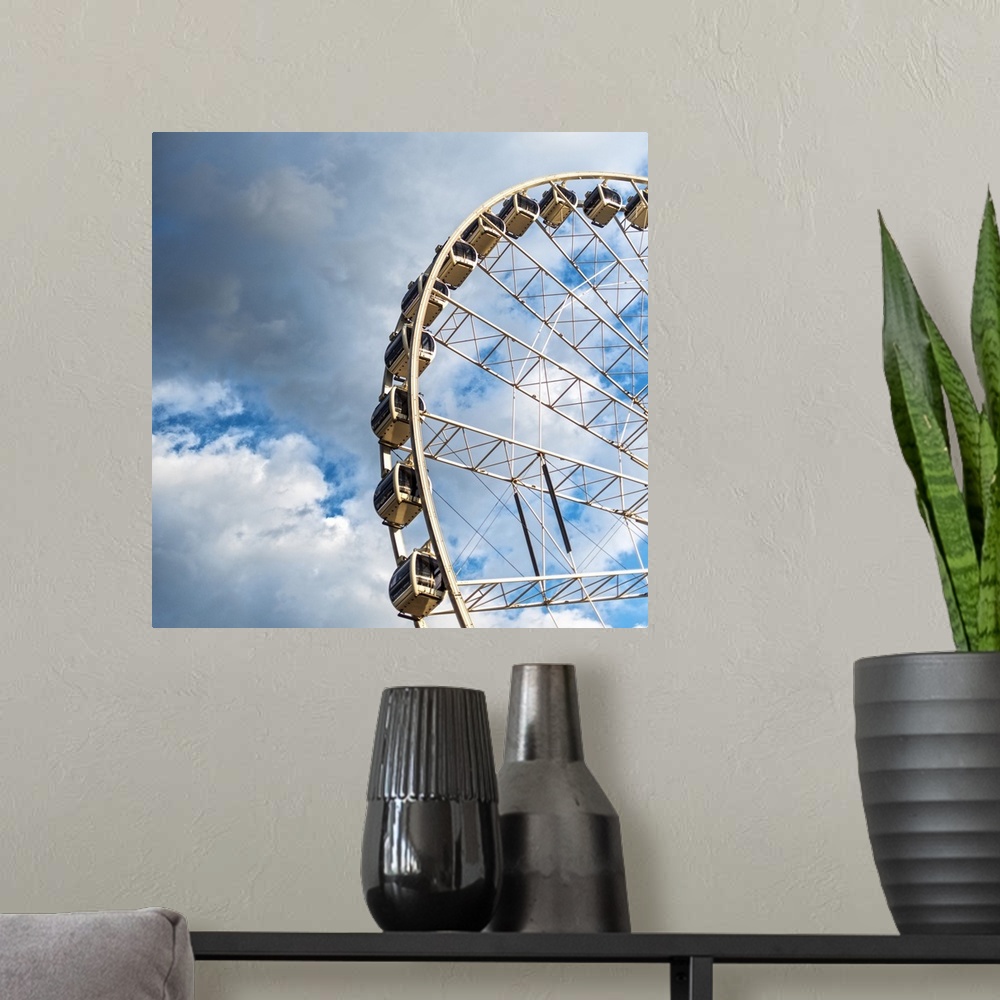 A modern room featuring The gondolas of SkyView Atlanta Ferris Wheel, a 20-story wheel, against a backdrop of clouds over...