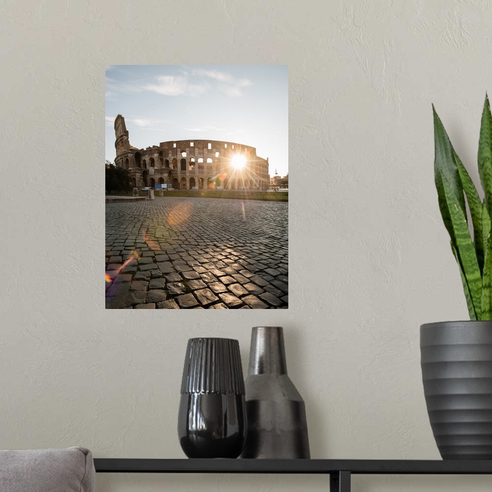 A modern room featuring Photograph of the sun shining right though the middle of the Colosseum.