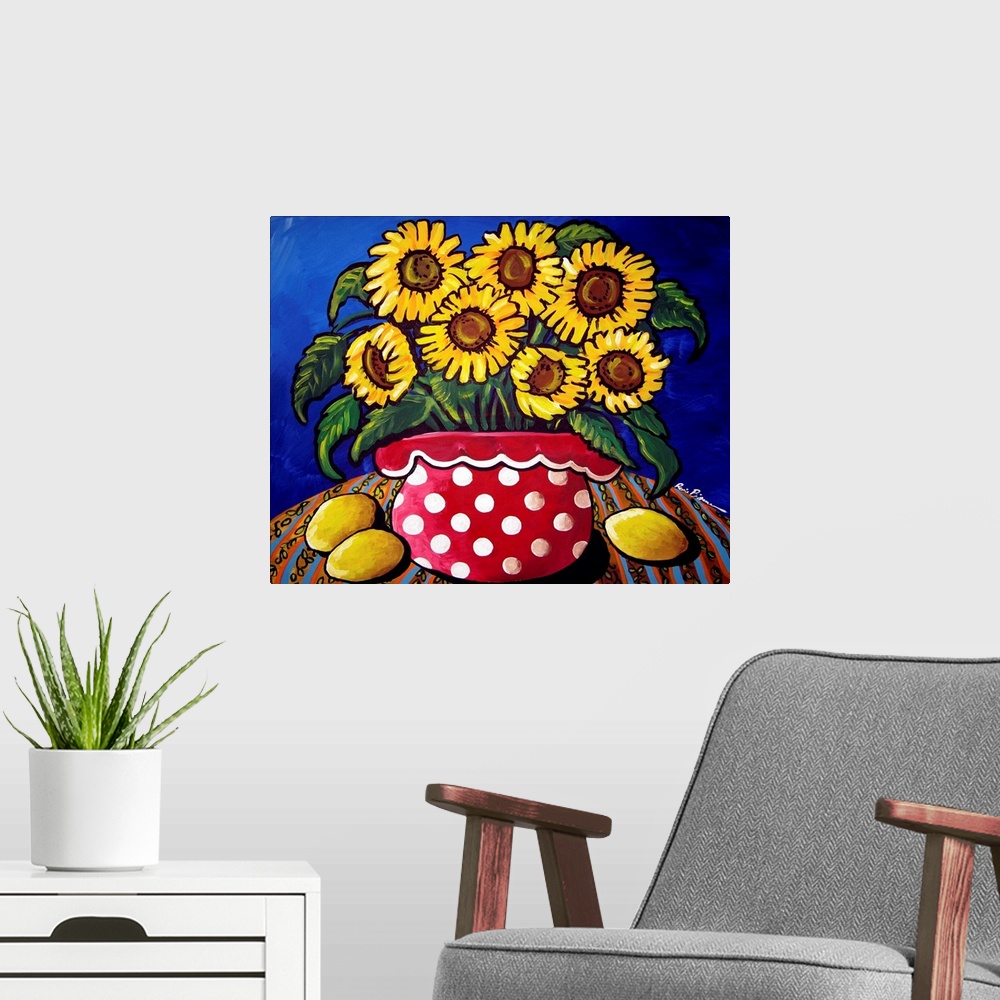 A modern room featuring Fun and colorful red polka dotted vase filled with sunflowers. Three lemons sit along side.