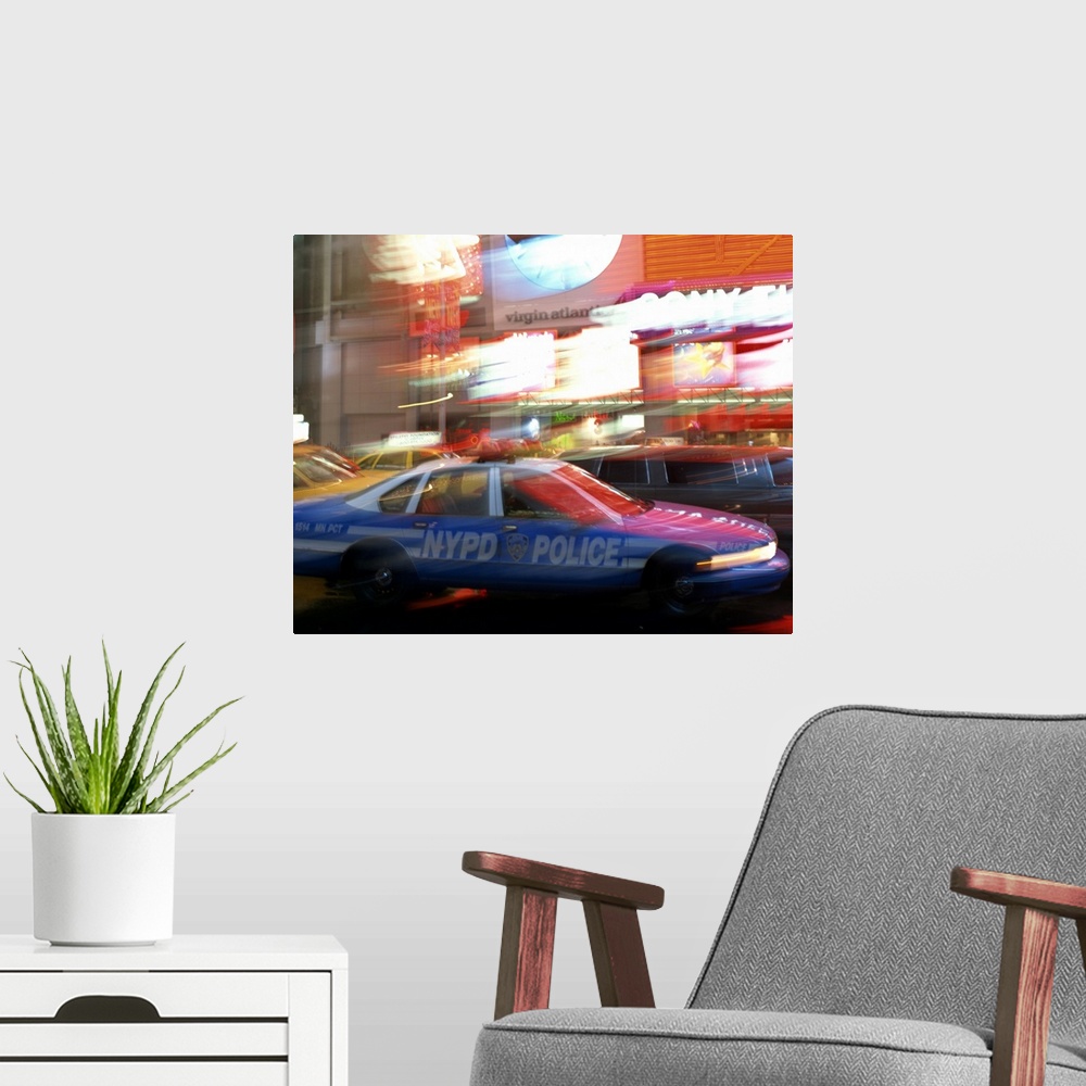 A modern room featuring NYPD police car speeding through Times Square, New York City, New York