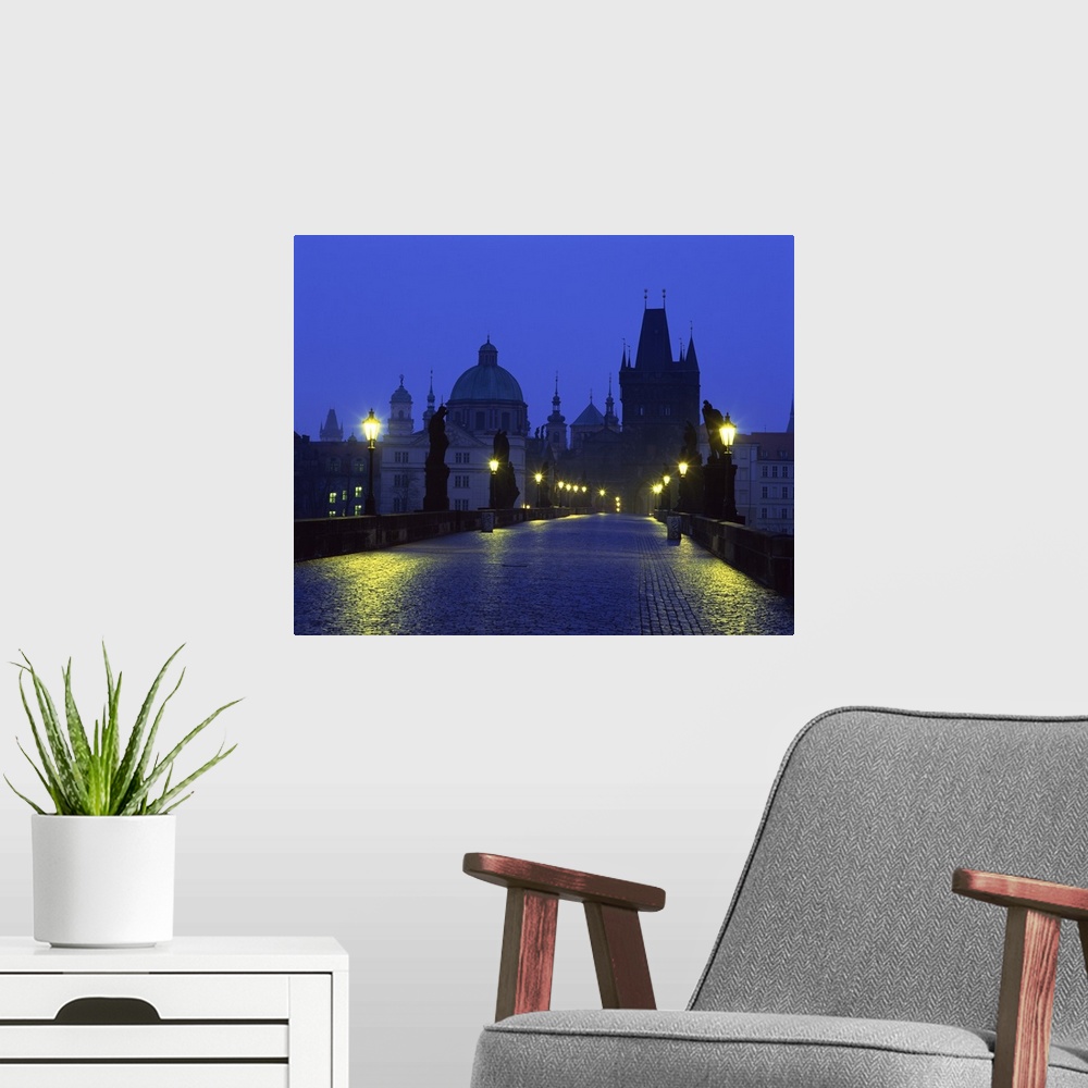 A modern room featuring The Charles Bridge at night and city skyline with spires, Prague, Czech Republic