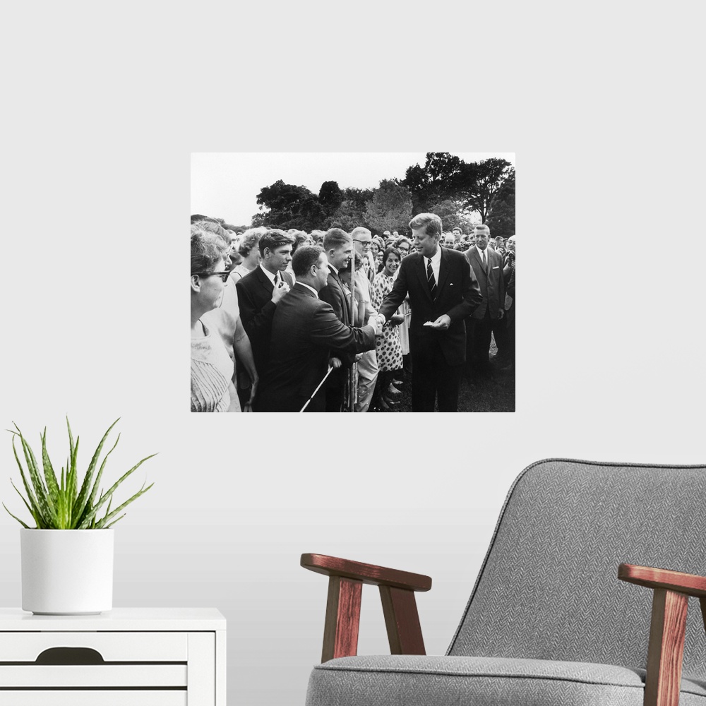 A modern room featuring President Kennedy greets Peace Corps Volunteers on the White House South Lawn.