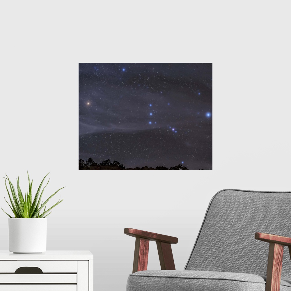 A modern room featuring The Orion constellation rises over a hill through high thin clouds near Black Mesa, Oklahoma.