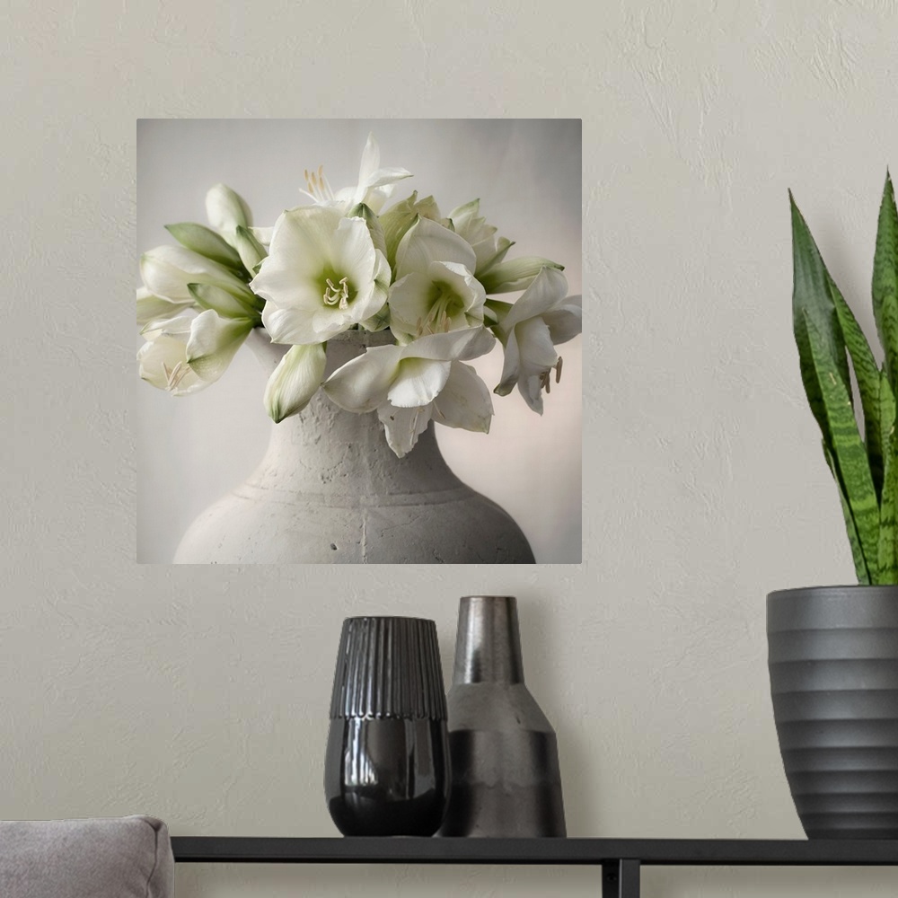 A modern room featuring A large bouquet of white flowers in a large stone vase.