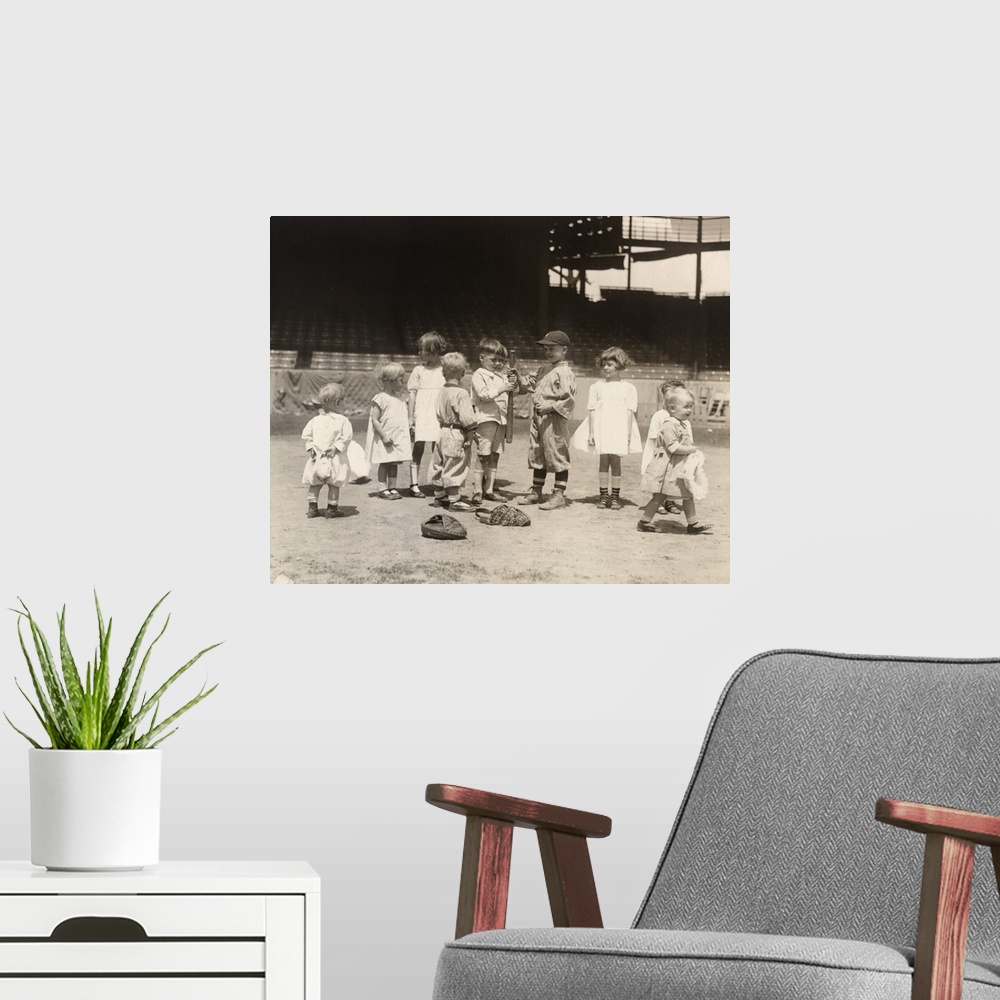 A modern room featuring Young boys and girls on a baseball field at a major league stadium. Photograph, early 20th century.