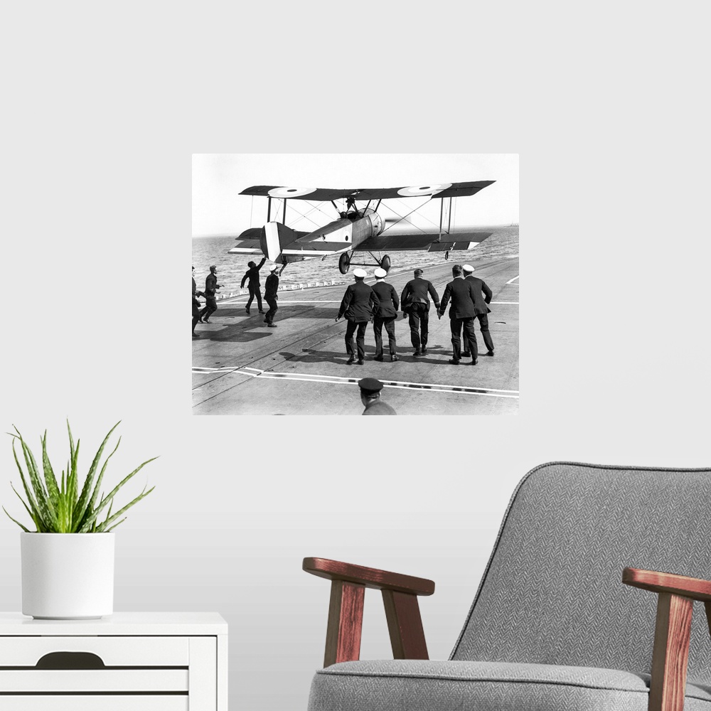 A modern room featuring Squadron Commander Edwin Harris Dunning landing his Sopwith Pup biplane on the HMS 'Furious,' the...