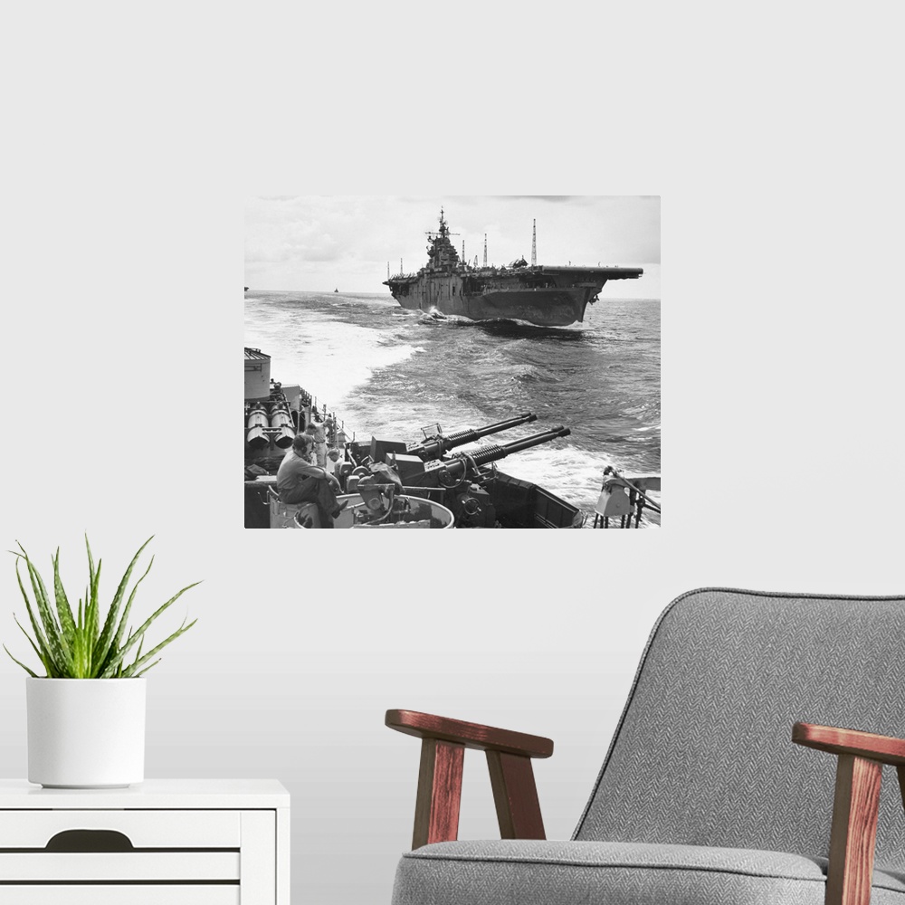 A modern room featuring The USS Essex aircraft carrier as seen from the USS Ault, off the coast of Japan, July 1943.