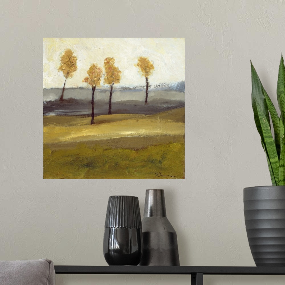 A modern room featuring Contemporary landscape painting with four trees in autumn foliage standing together in the distance.