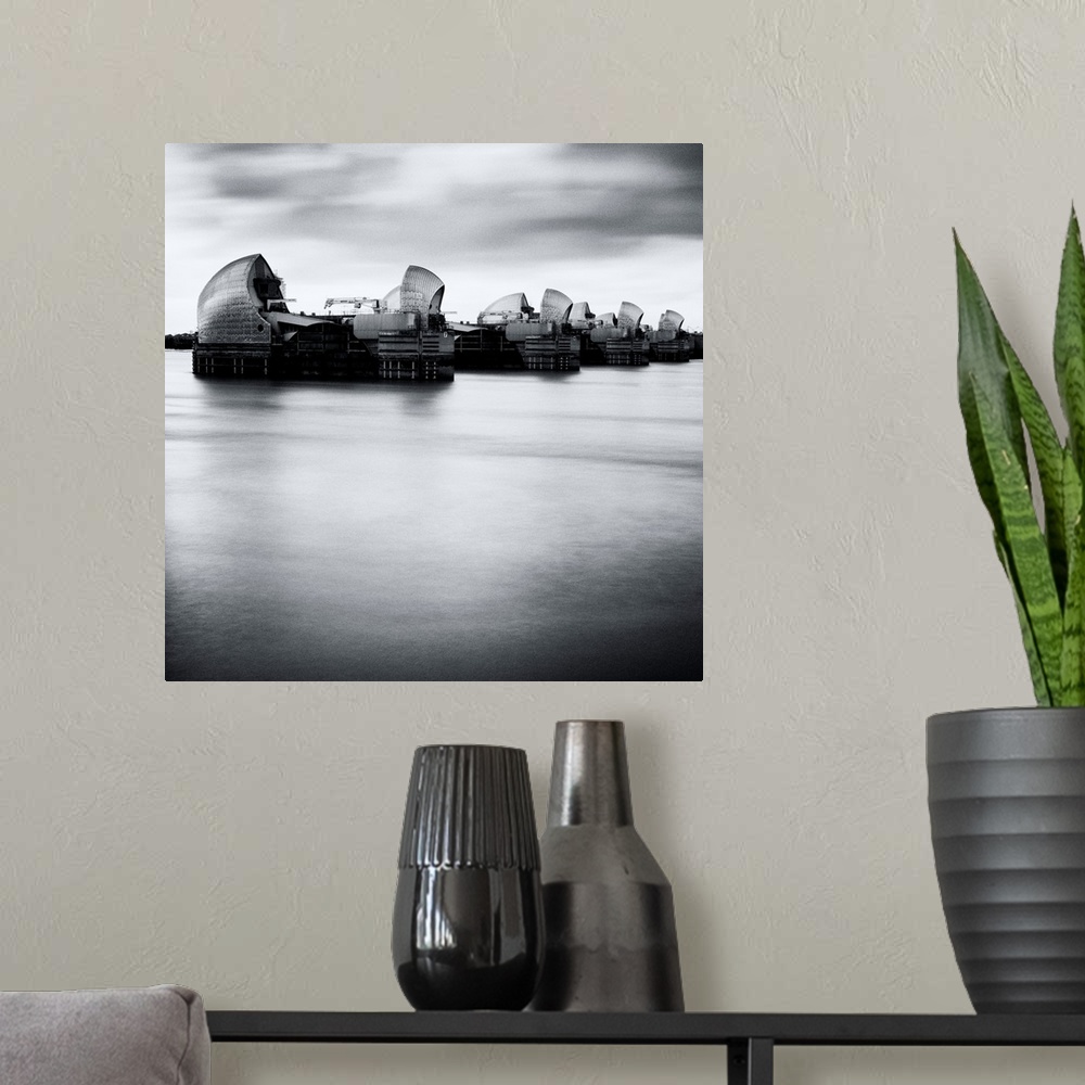 A modern room featuring Thames Barrier, london with Canary Wharf in background under grey sky