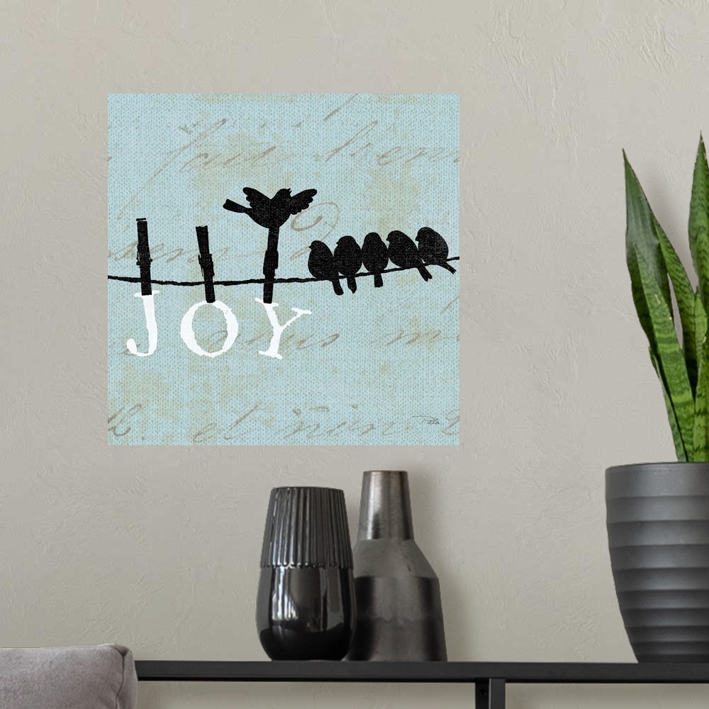 A modern room featuring Contemporary artwork of birds silhouetted on a cloths line, with the word "JOY" hanging from the ...