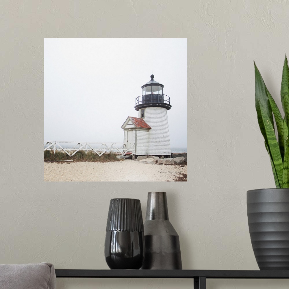 A modern room featuring A square photograph of the Brant Point Lighthouse in Nantucket Island, Massachusetts, blanketed i...