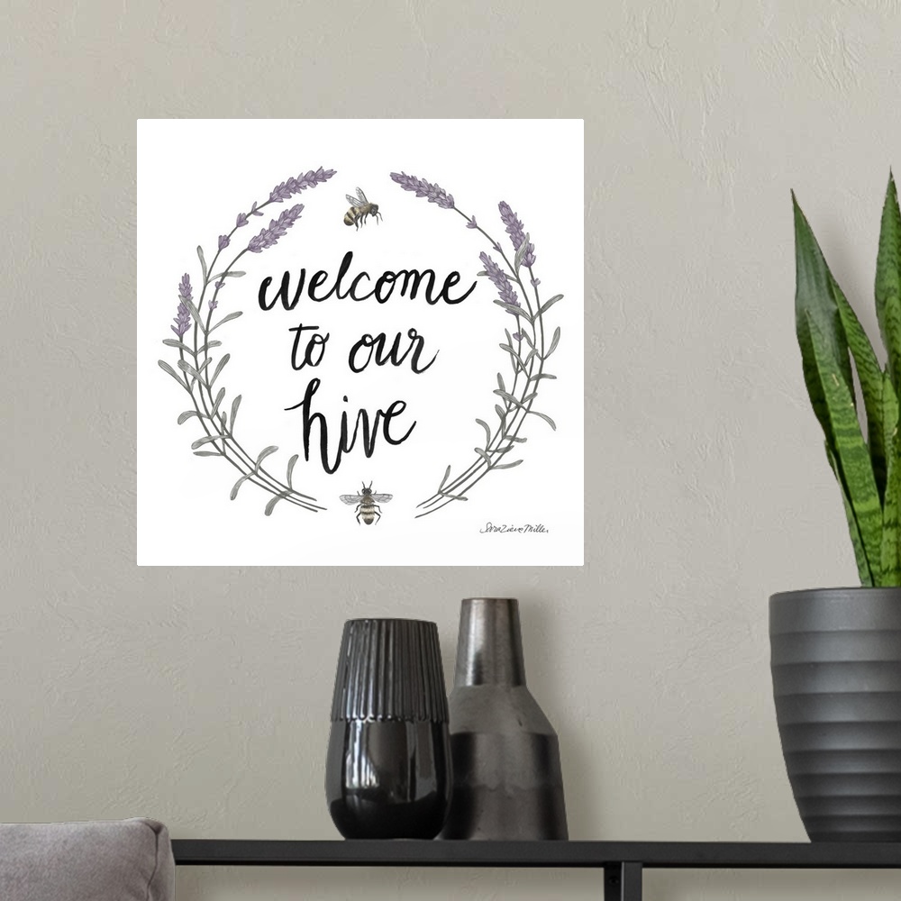 A modern room featuring "Welcome To Our Hive" framed with a wreath of purple flowers and bees.