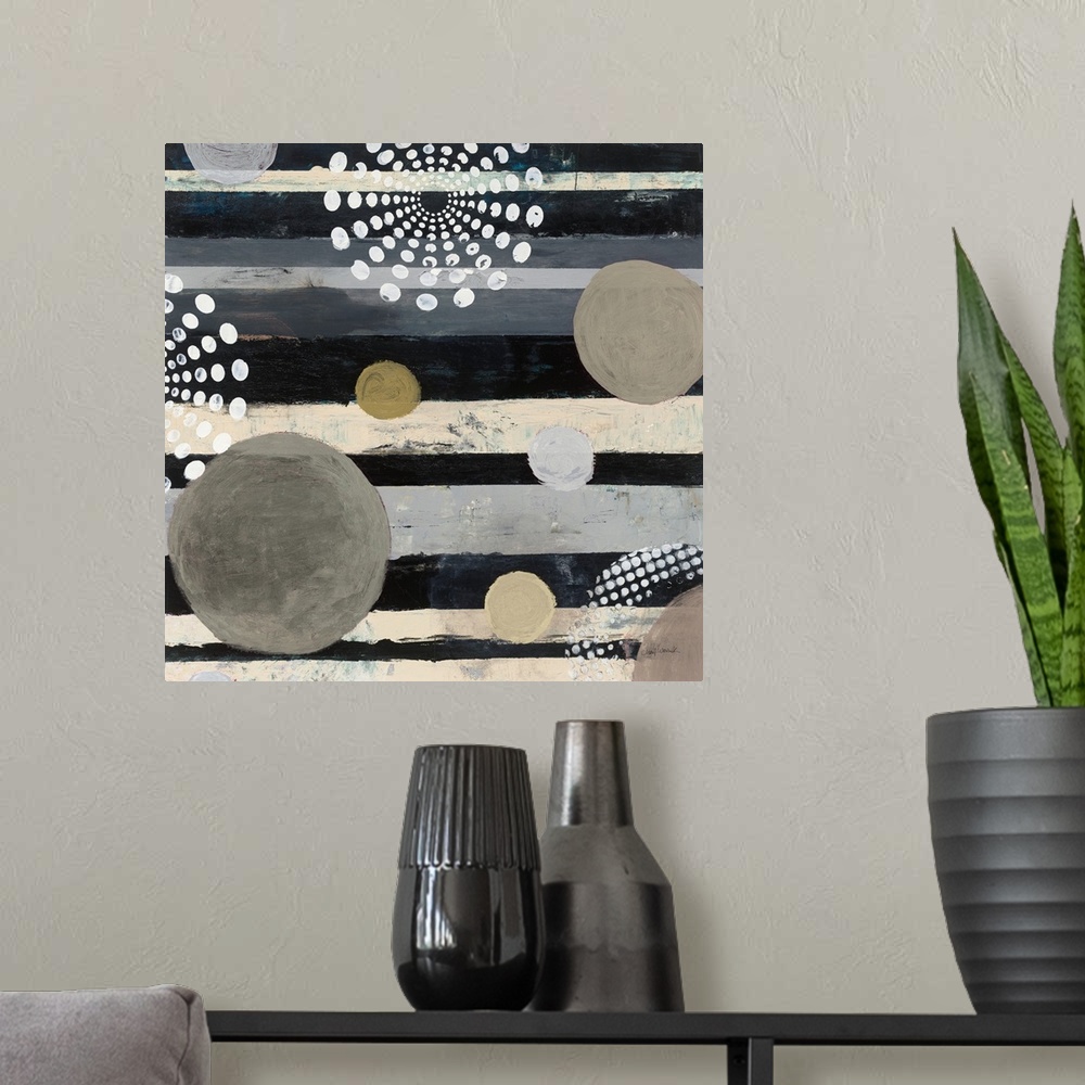 A modern room featuring Square abstract art with a striped background and different colored circles on top.