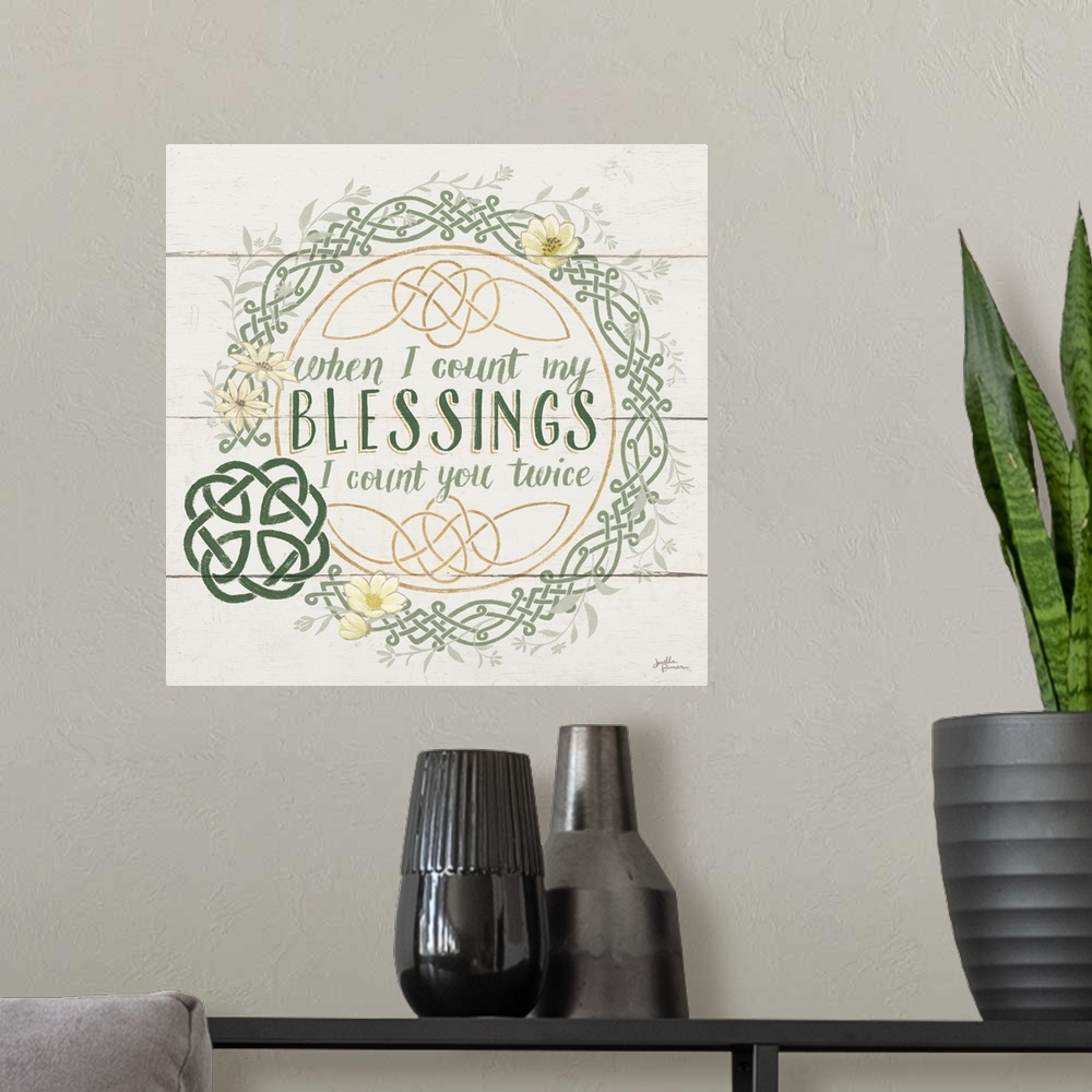 A modern room featuring "When I Count My Blessings I Count You Twice"  inside a Celtic knot wreath, on a wood paneled bac...