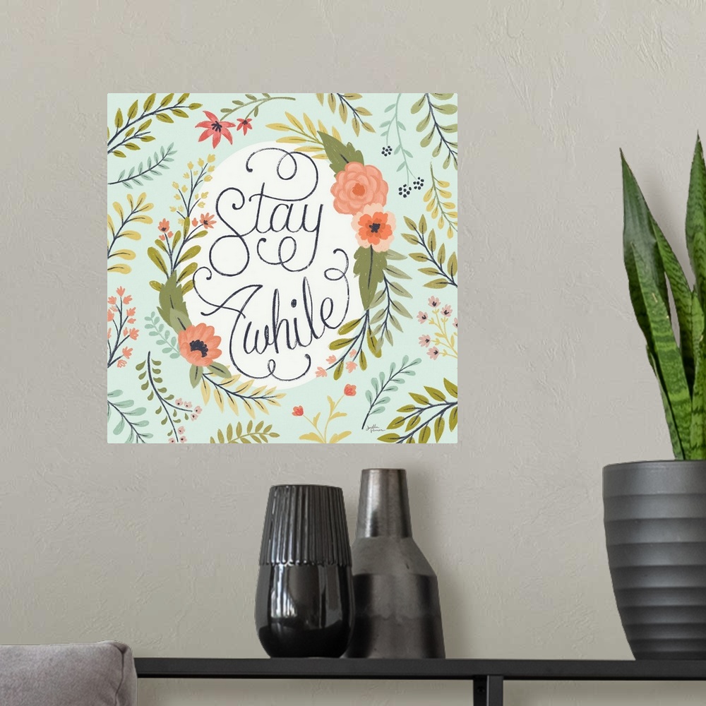 A modern room featuring "Stay Awhile" handwritten with loopy finishes, inside of a floral display on a mint colored backg...