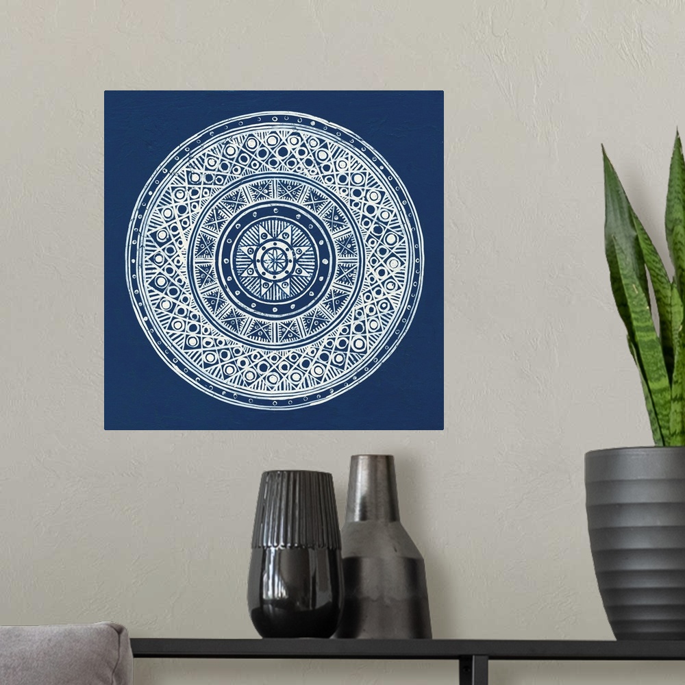 A modern room featuring Square abstract art with a white symmetrically designed mandala on an indigo background.