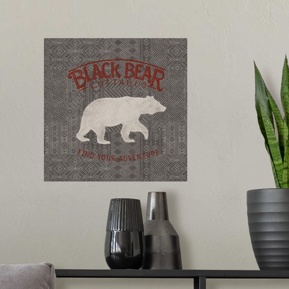 A modern room featuring "Black Bear Cottages" "Find Your Adventure" written in red on a gray patterned background with a ...