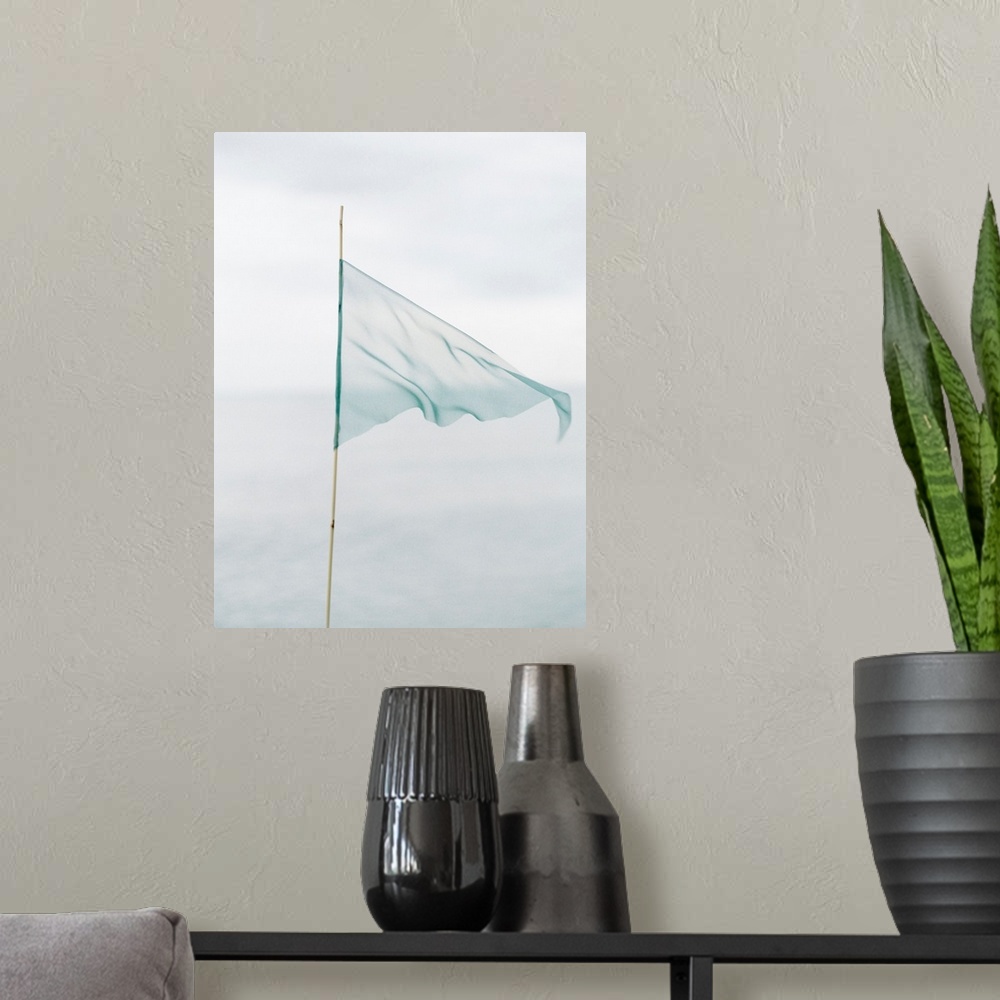 A modern room featuring Photograph of a delicate blue flag made from thin fabric on a bamboo pole.