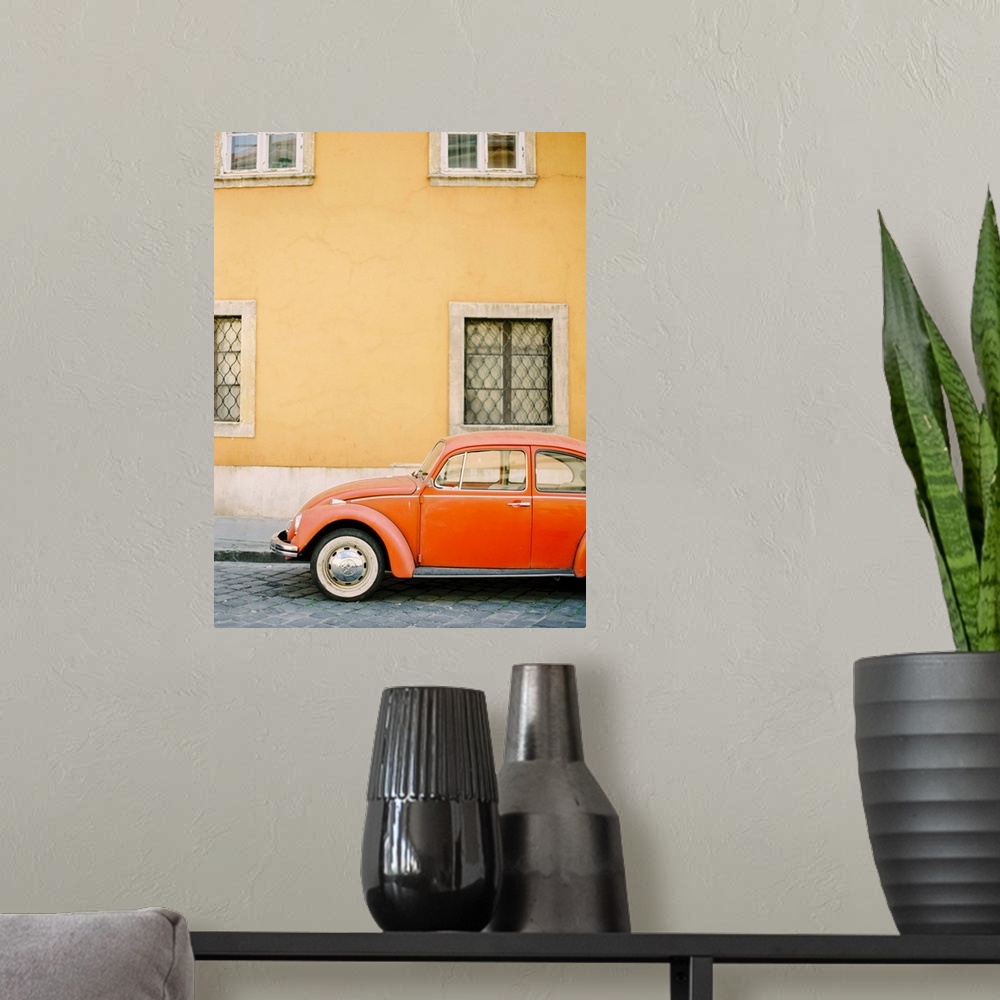 A modern room featuring Photograph of an orange Volkswagen Beetle car parked in front of a yellow wall, Budapest, Hungary.