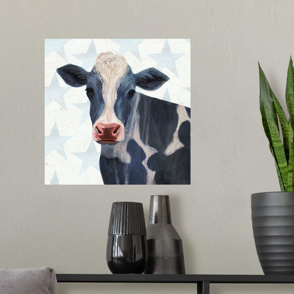 A modern room featuring Square painting of a black and white spotted cow on a gray and white star patterned background.