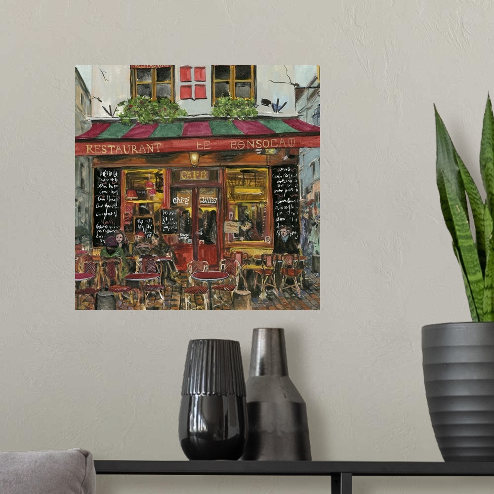 A modern room featuring A square decorative image of people sitting outside a red and green cafe in France.