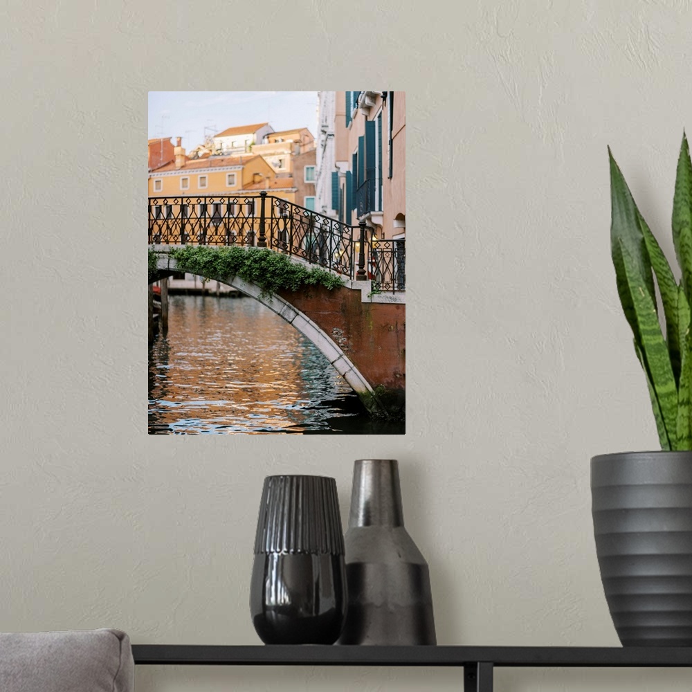 A modern room featuring A photograph of a beautiful wrought iron and stone bridge crossing a canal in Venice, Italy.