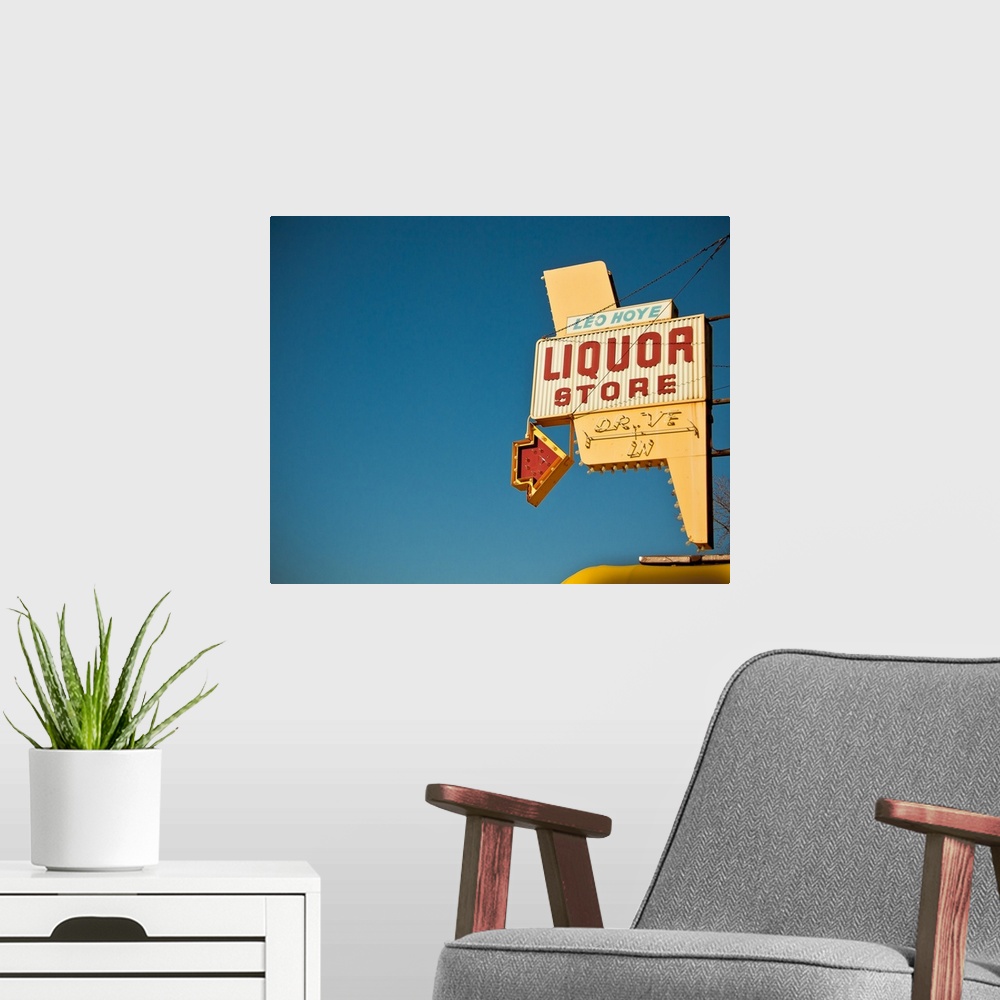 A modern room featuring Photograph of mid-century liquor store sign against a blue sky.