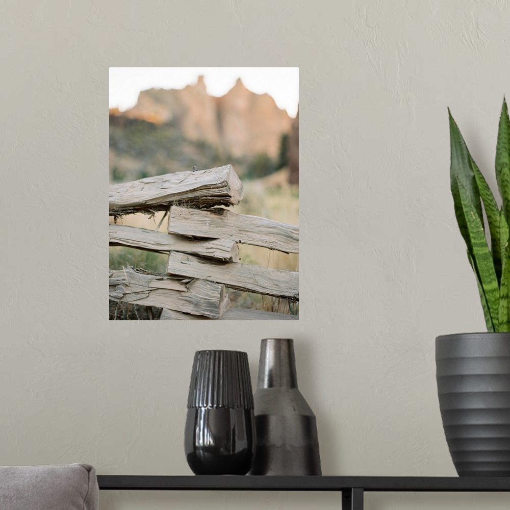 A modern room featuring A close up photograph of a rustic split rail fence in front of a large mountain.