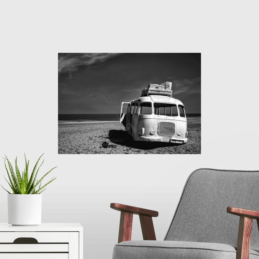 A modern room featuring Black and white image of an abandoned bus with windows missing on a sandy beach in Belgium.